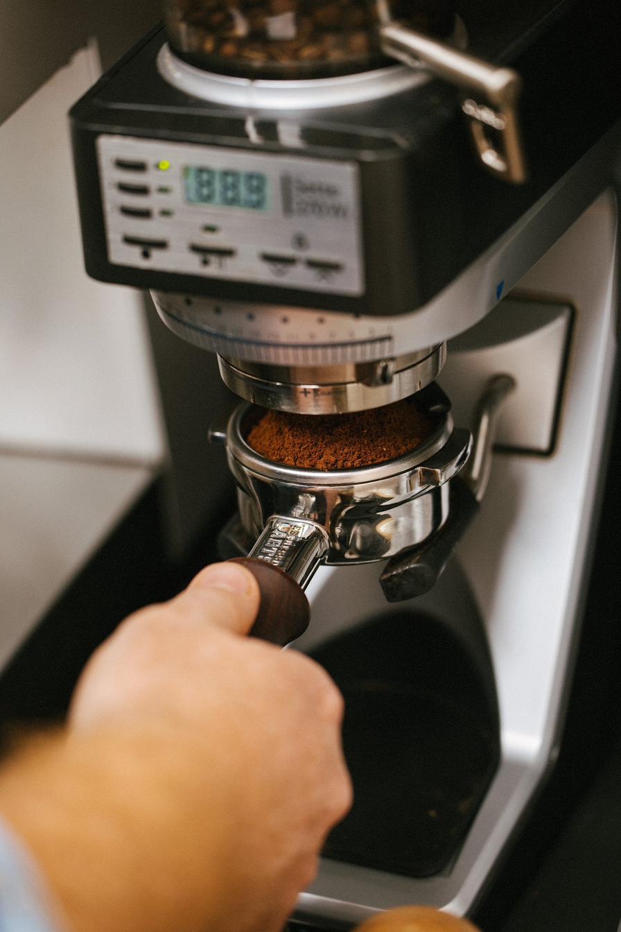 Barista dosing espresso at the grinder