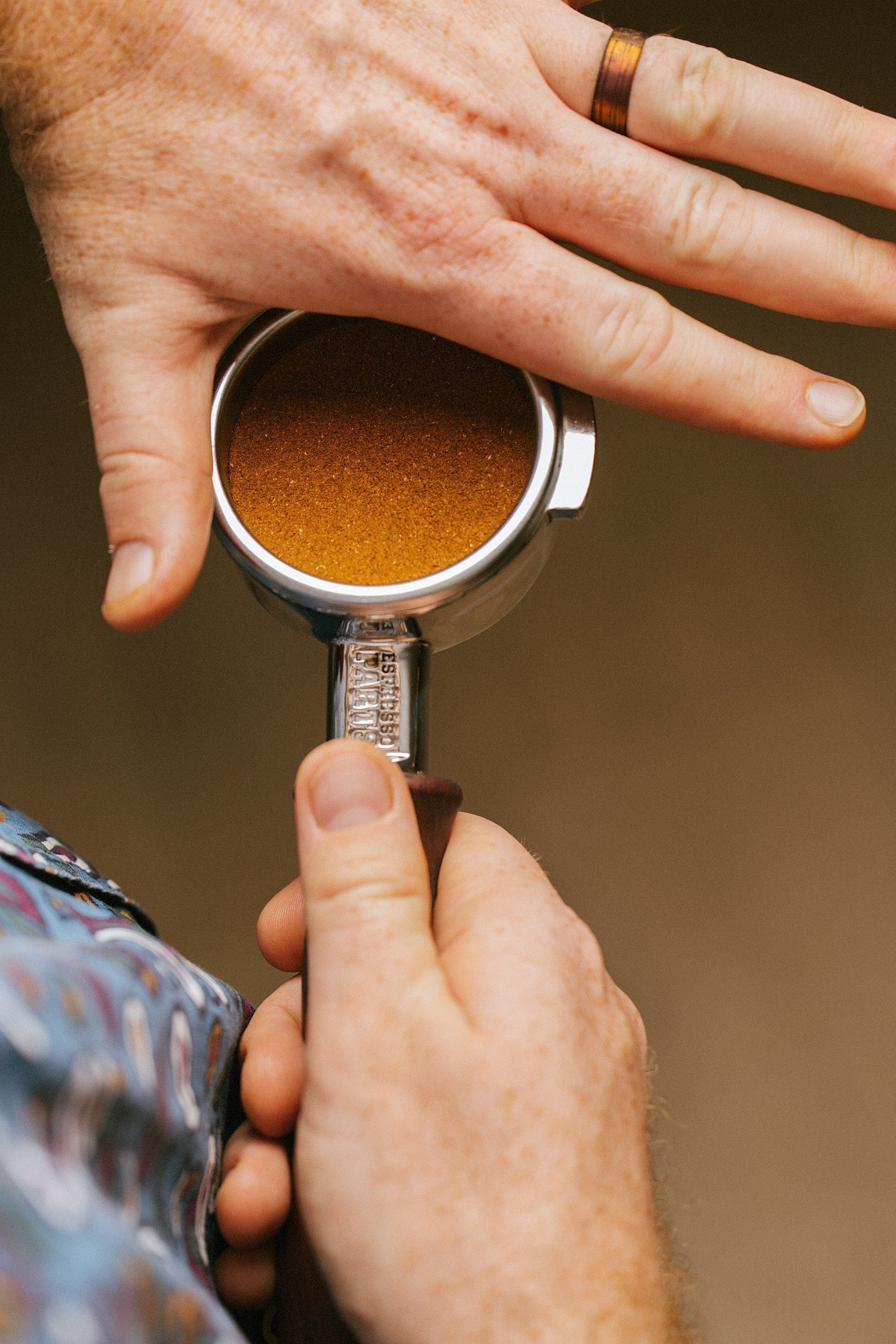 Barista holding a portafilter packed with espresso
